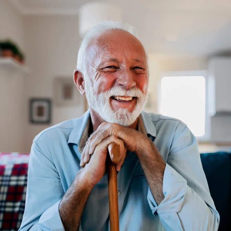 man leaning on cane smiling