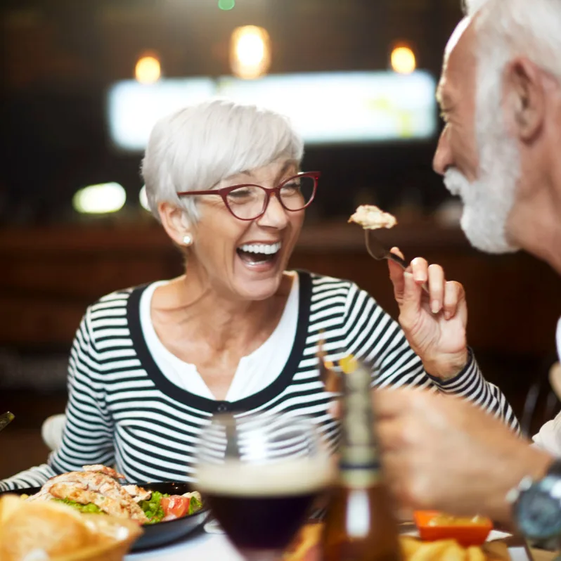 senior woman smiling with food on fork